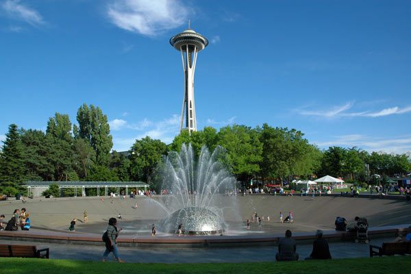Seattle Center fountain with the Space Needle towering above on a sunny day