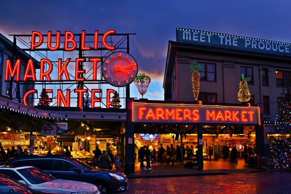 Pike Place Public Market Center and Farmers Market neon signs glowing at dusk in Seattle